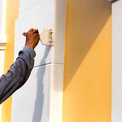 Man Painting the Outside of House with Brush